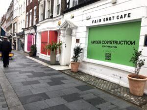 A cafe in London with coming soon signs in bright colors.