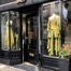 A shop window in London, with a chartreuse outfit in the window - a combination of Pantone's Spring/Summer 2023 fashion colors Blazing Yellow and Titanite.