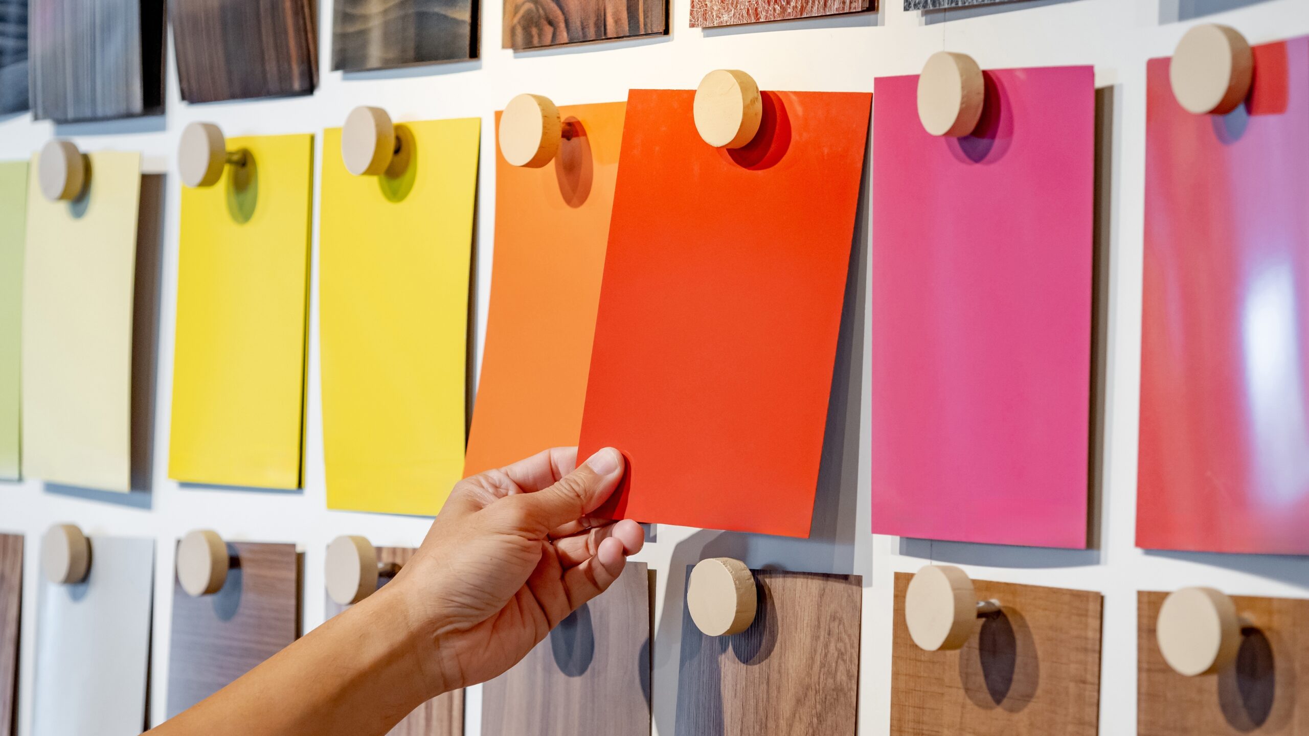 A color expert chooses a color swatch from a swatch board.