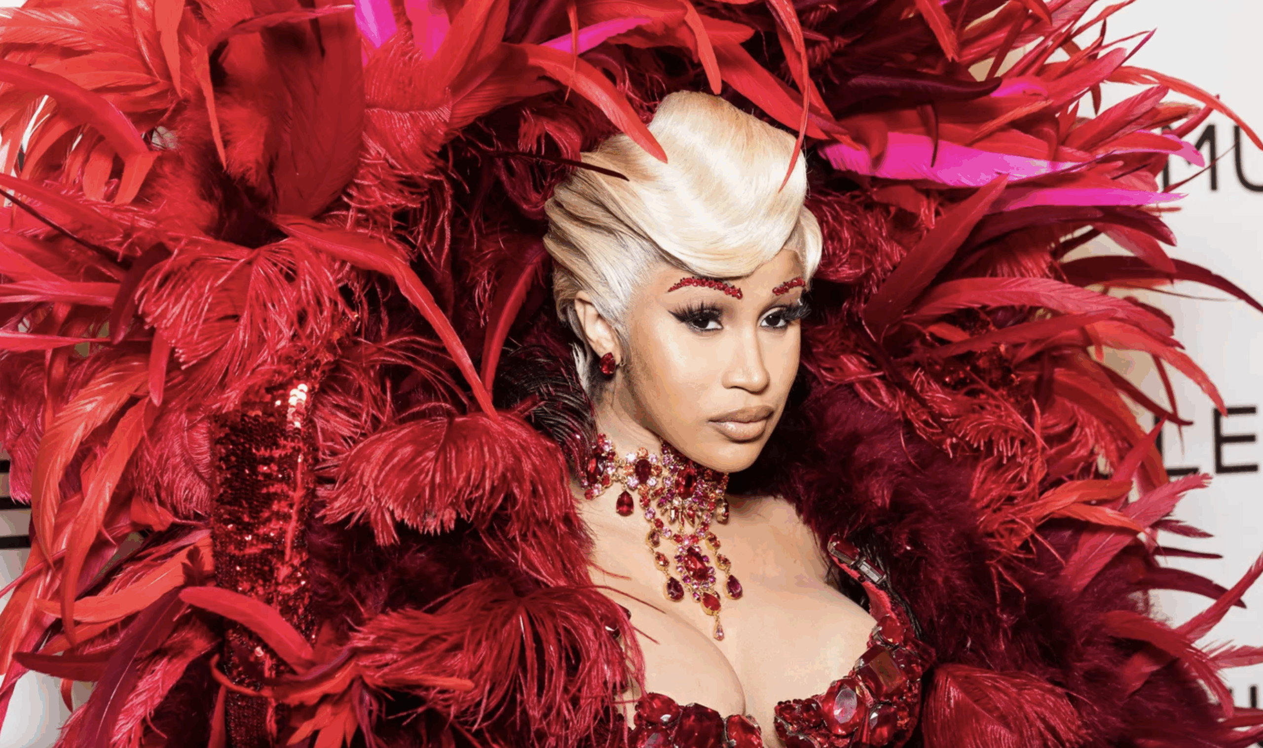 Cardi B surrounded by red feathers, photographed at Paris Fashion Week in 2025